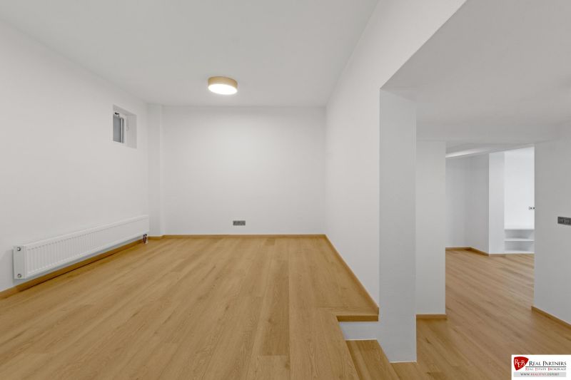 ,Prenájom moderný 3 izb. byt, Sološnícka ul,124 m2, Karlova Ves - Izba v rodinnom dome s podlahou s dreveným dekorom a bielymi stenami.