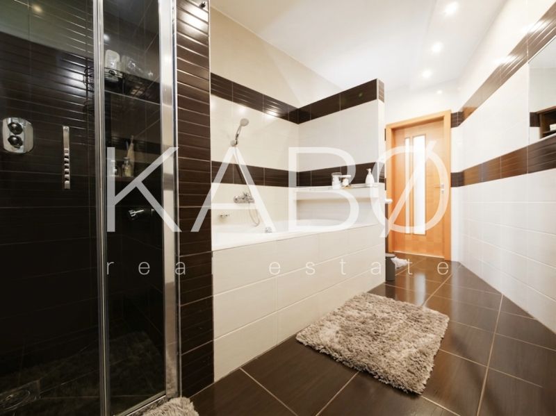 Nadštandardný 5-izbový RD - veľkorysý pozemok - moderné technológie - Kúpeľňa v rodinnom dome s vaňou, sprchovacím kútom a dlažbou s dreveným dekorom.