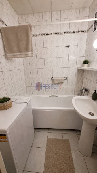 2-izbový byt, 51 m², samostatné izby, tichý, výhľad do zelene,K.Adlera - Kúpeľňa s obkladačkami a vaňou v 2-izbovom byte, interiér s práčkou a umývadlom.