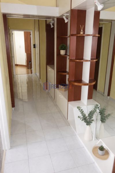 2-izbový byt, 51 m², samostatné izby, tichý, výhľad do zelene,K.Adlera - Chodba so zabudovanými policami a dlažbou v 2-izbovom byte s rastlinnými dekoráciami.