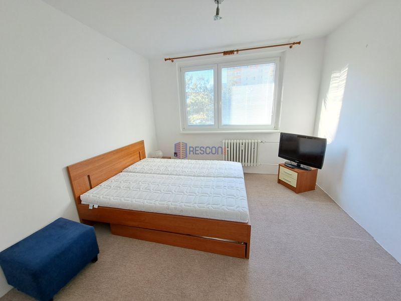2-izbový byt, 51 m², samostatné izby, tichý, výhľad do zelene,K.Adlera - Svetlá spálňa v 2-izbovom byte s manželskou posteľou a televízorom.