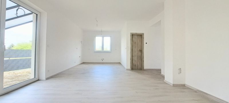 Novostavba pri jazere - 4 izbový rodinný dom v štandarde v obci Selice - Interiér rodinného domu s oknom a podlahou s dreveným dekorom.