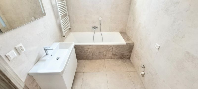 Novostavba pri jazere - 4 izbový rodinný dom v štandarde v obci Selice - Kúpeľňa s vaňou, umývadlom a rebríkovým radiátorom v rodinnom dome.