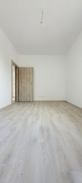 Novostavba pri jazere - 4 izbový rodinný dom v štandarde v obci Selice - Izba s podlahou s dreveným dekorom a drevenými dverami v rodinnom dome.