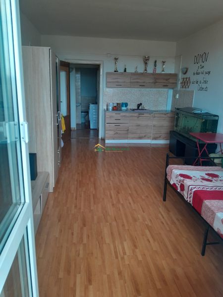 Predaj, Garsónka, Žiar nad Hronom  - Garsónka s podlahou s dreveným dekorom, kuchynskou linkou a akváriom v rohu.