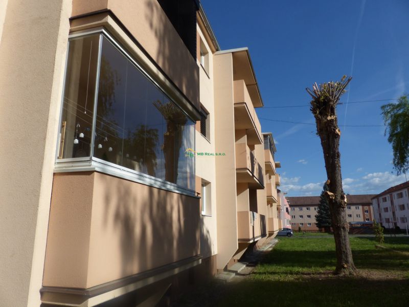 Predaj, 2 - izbový byt, Žiar nad Hronom - Bytový dom s balkónmi a upravenými stromami v Žiari nad Hronom, vhodný pre 2-izbový byt.