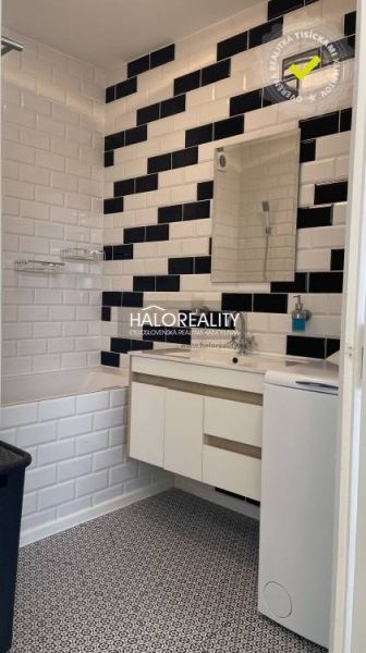 Prenájom, dvojizbový byt Komárno, s balkónom, blízko... - Kúpeľňa v 2-izbovom byte s mozaikovou podlahou, bielo-čiernym obkladom a umývadlom.