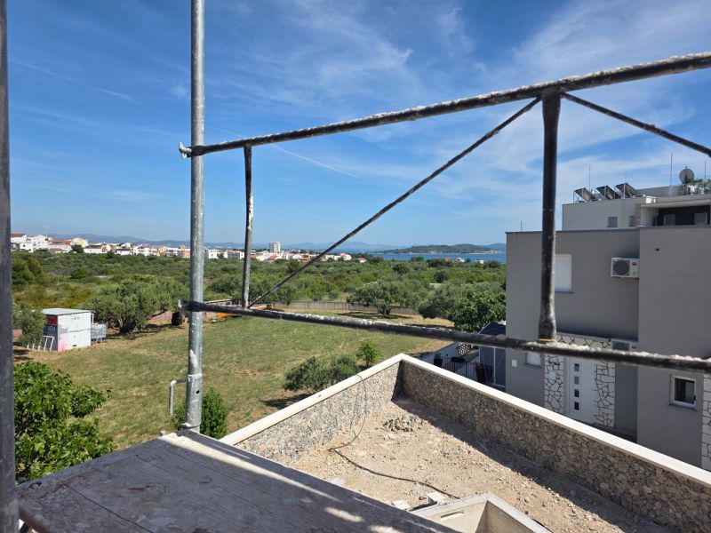 CHORVÁTSKO  - Apartmány v krásnej dedinke TRIBUNJ - Výhľad z 3-izbového bytu v TRIBUNJ ukazuje stavbu a panorámu s morom.