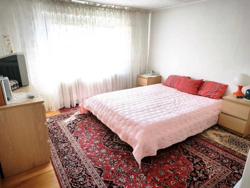 Priestranný 6-izbový rodinný dom v srdci Vysokej nad Kysucou – komfort - Spálňa v rodinnom dome s posteľou, červeným kobercom a svetlými závesmi.