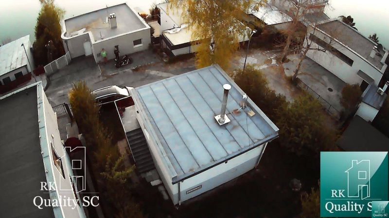 SENEC – SLNEČNÉ JAZERÁ JUH – NA PREDAJ - romantická rekreačná chata s  - Chata v Senec na SLNEČNÉ JAZERÁ JUH, s plochou strechou, okolitými stromami a cestou.