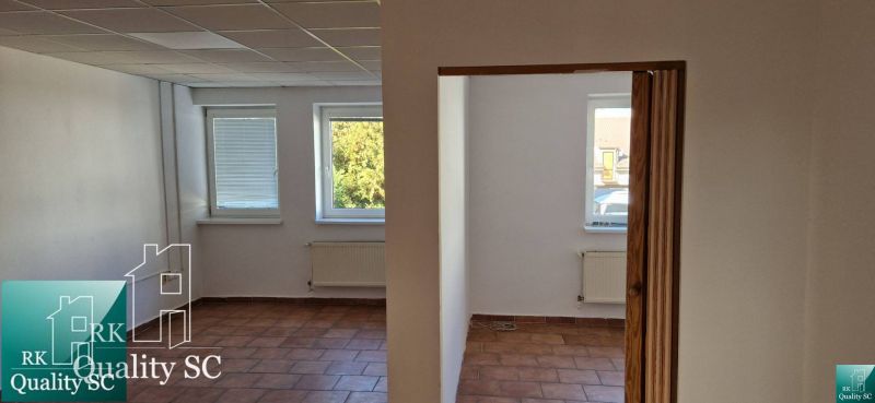 NA PREDAJ – polyfunkčný objekt v úplnom centre mesta Senec - obchodný  - Interiér rodinného domu s terakotovou podlahou, bielymi stenami a radiátormi pod oknami.