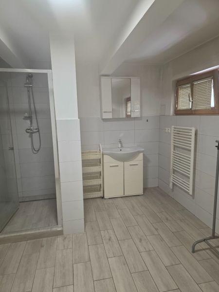 Moderný prenájom na ulici Bakossova za 550 € mesačne - Kúpeľňa so sprchovým kútom, umývadlom a podlahou s dreveným dekorom v 1-izbovom byte.