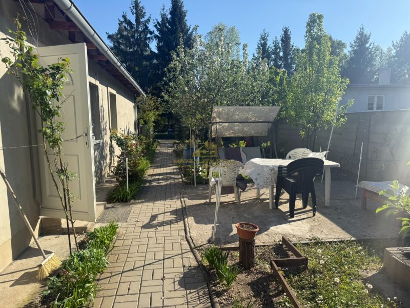 NA PREDAJ celoročná chata – Sekule (Šutrovňa), tiché prostredie - Záhrada pri chate na ulici Sekule v Sekulách s posedením a kvetinovým záhonom.
