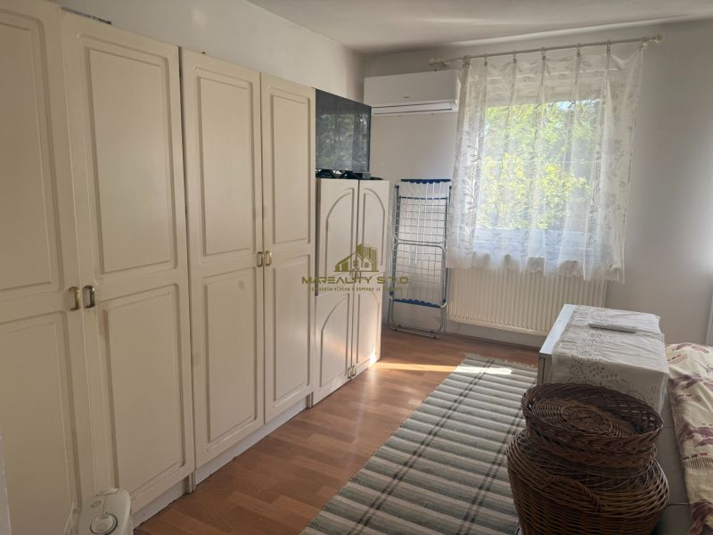 NA PREDAJ celoročná chata – Sekule (Šutrovňa), tiché prostredie - Izba s bielymi skriňami, oknom a podlahou s dreveným dekorom v Chate.