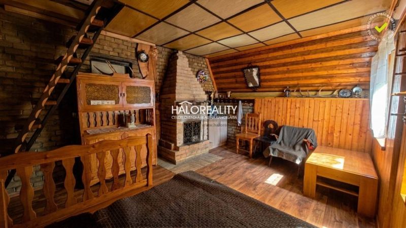 Predaj, chata Chyžné - EXKLUZÍVNE HALO REALITY - Interiér chaty s tehlovým krbom, schodmi a dreveným dekorom na stenách aj podlahe.