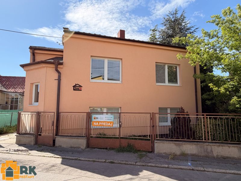 Predaj rodinného domu Piešťany - Rodinný dom na Mlynskej ulici v Piešťanoch s bielymi oknami, oranžovou fasádou a plotom.