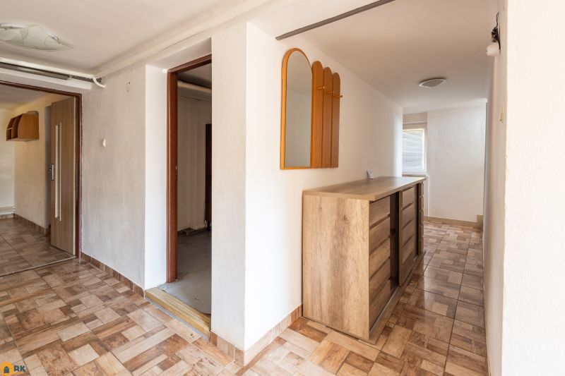 Predaj rodinného domu Piešťany - Interiér rodinného domu so skrinkou a zrkadlom, podlaha s dreveným dekorom.