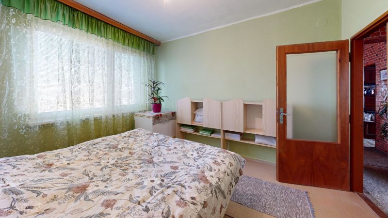 Štvorizbový byt  85 m2 s garážou a záhradou, Hlboké - okres Senica - Spálňa v 4-izbovom byte so zelenými závesmi a vzorovaným prádílom.