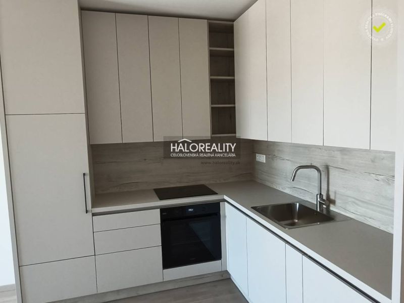 Predaj, jednoizbový byt Bratislava Staré Mesto, Bott... - Kuchyňa v 1-izbovom byte s bielymi skrinkami a podlahou s dreveným dekorom.