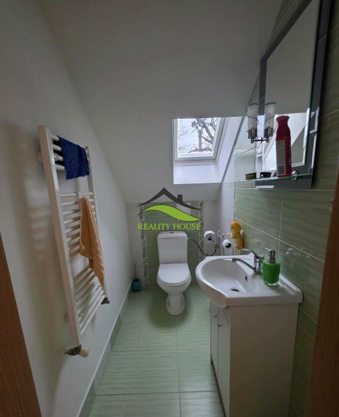 Poschodový rodinný dom v  obci Klokočov okr. Michalovce - Kúpeľňa v rodinnom dome so strešným oknom a zelenými obkladmi.
