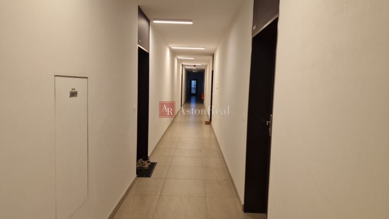 Exkluzívne 2 izbový byt POPRAD Karpatská, s garaž. st., balkón, 58 m2 - Chodba v 2-izbovom byte s jednoduchým interiérom a dlažbou na podlahe.