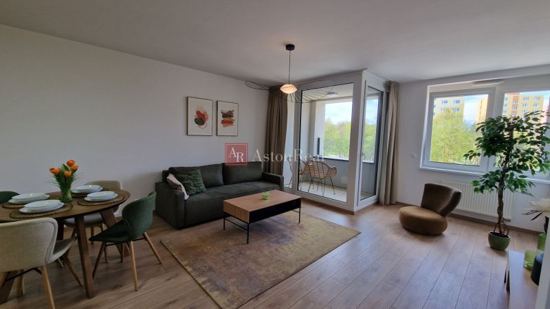 Exkluzívne 2 izbový byt POPRAD Karpatská, s garaž. st., balkón, 58 m2 - Obývačka v 2-izbovom byte s podlahou s dreveným dekorom a presklenou lodžiou.
