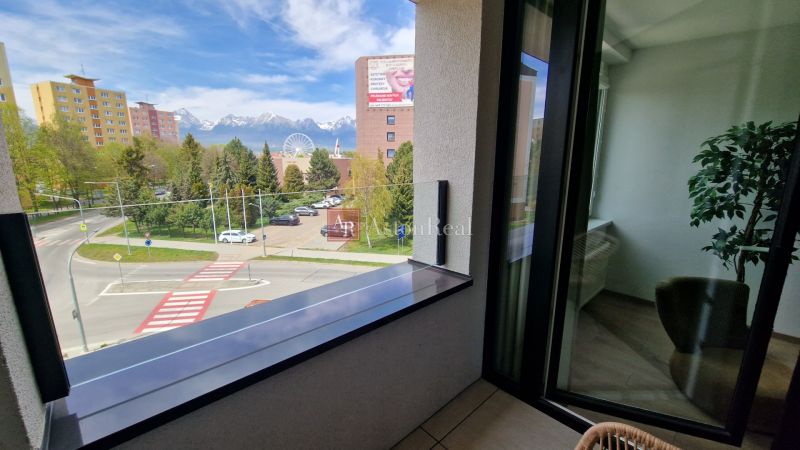 Exkluzívne 2 izbový byt POPRAD Karpatská, s garaž. st., balkón, 58 m2 - Výhľad z 2-izbového bytu na Karpatskej ulici v Poprade so zasneženými horami v pozadí.