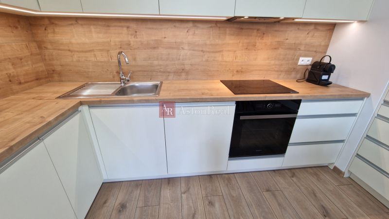 Exkluzívne 2 izbový byt POPRAD Karpatská, s garaž. st., balkón, 58 m2 - Kuchyňa s pracovnou doskou z dreveného dekoru a vstavanými spotrebičmi v 2-izbovom byte.