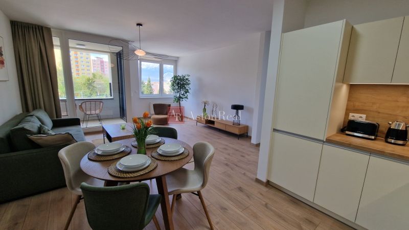 Exkluzívne 2 izbový byt POPRAD Karpatská, s garaž. st., balkón, 58 m2 - Obývacia izba s kuchynským kútom v 2-izbovom byte s podlahou s dreveným dekorom.