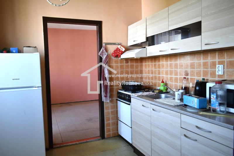  REZERVOVANÉ 3-izbový byt s balkónom na sídlisku Juh - Kuchyňa v 3-izbovom byte s dlaždicovým obkladom a podlahou s dreveným dekorom.