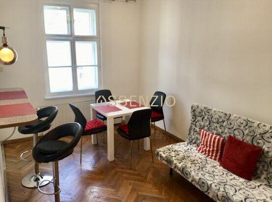 – PRENAJOM – 2 IZBOVÝ – MURGAŠOVA – STARE MESTO  - Obývací priestor v 2-izbovom byte s podlahou s dreveným dekorom a jedálenským stolom.