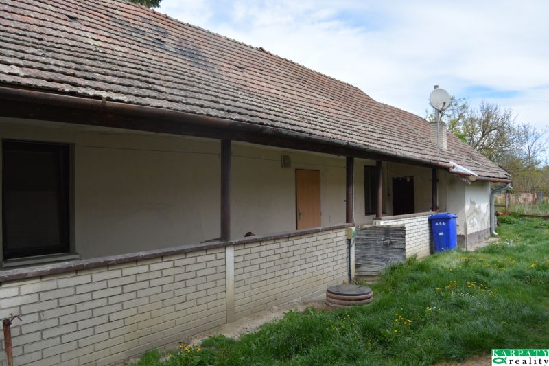 Domček na chalupárčenie s veľkým pozemkom s termál kúpaliskom v obci! - Exteriér rodinného domu v Horných Salibách so sedlovou strechou a tehlovým obkladom.