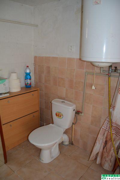 Domček na chalupárčenie s veľkým pozemkom s termál kúpaliskom v obci! - Kúpeľňa v rodinnom dome s WC, nábytkom, fľašou a ohrievačom vody.