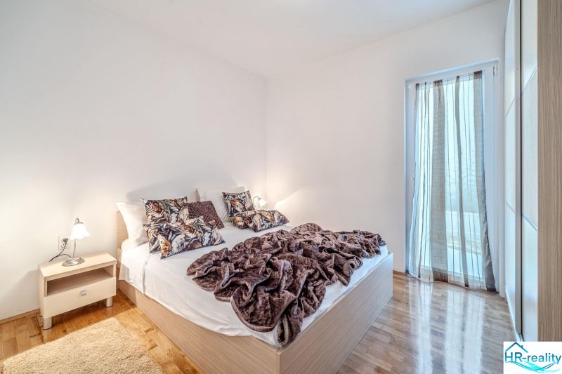 Brač(HR) - Apartmány v 1. rade u mora !!! - Svetlá spálňa s posteľou a podlahou s dreveným dekorom v Rekreačnom apartmáne.