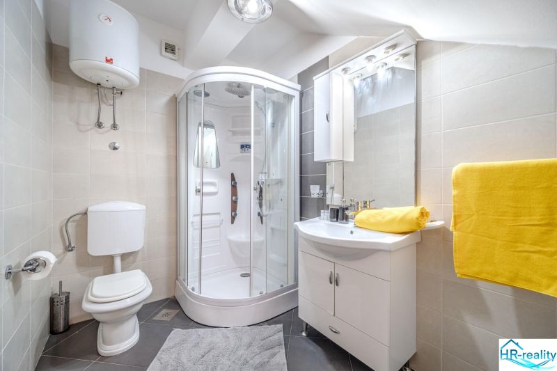 Brač(HR) - Apartmány v 1. rade u mora !!! - Kúpeľňa v rekreačnom apartmáne s moderným sprchovacím kútom a jasnými žltými uterákmi.