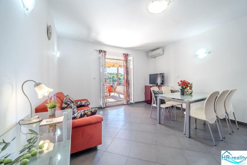 Brač(HR) - Apartmány v 1. rade u mora !!! - Svetlá obývačka s pohovkou, jedálenským stolom a terasou v Rekreačnom apartmáne.