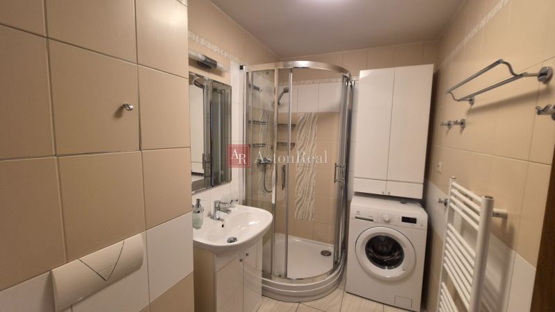 Investičný apartmán Vysoké Tatry - Stará Lesná s balkónom a park.miest - Kúpeľňa s umývadlom, sprchovým kútom a práčkou v rekreačnom apartmáne.