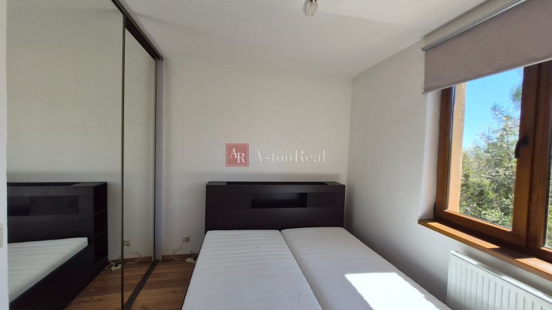 Investičný apartmán Vysoké Tatry - Stará Lesná s balkónom a park.miest - Spálňa v Rekreačnom apartmáne s podlahou s dreveným dekorom a šatníkovou skriňou.