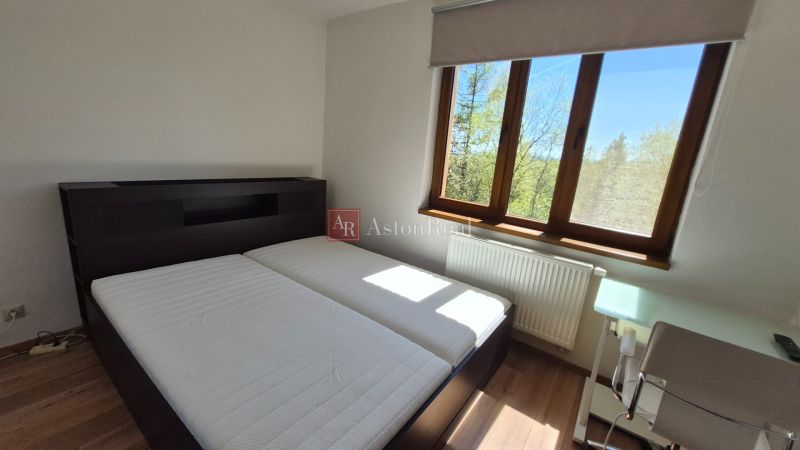 Investičný apartmán Vysoké Tatry - Stará Lesná s balkónom a park.miest - Spálňa s manželskou posteľou, podlahou s dreveným dekorom a oknom v Rekreačnom apartmáne.