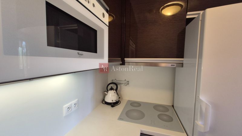 Investičný apartmán Vysoké Tatry - Stará Lesná s balkónom a park.miest - Kuchyňa rekreačného apartmánu s mikrovlnkou, varnou doskou a rýchlovarnou kanvicou.