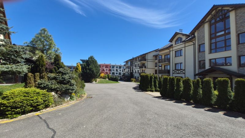 Investičný apartmán Vysoké Tatry - Stará Lesná s balkónom a park.miest - Zeleň v okolí rekreačných apartmánov na Starej Lesnej vo Vysokých Tatrách pod modrou oblohou.