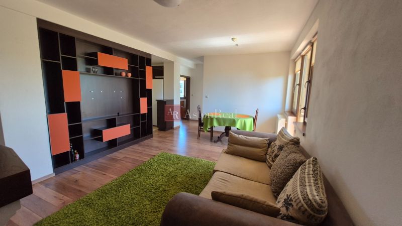 Investičný apartmán Vysoké Tatry - Stará Lesná s balkónom a park.miest - Rekreačný apartmán s podlahou s dreveným dekorom, sedačkou a farebnou stenovou zostavou.