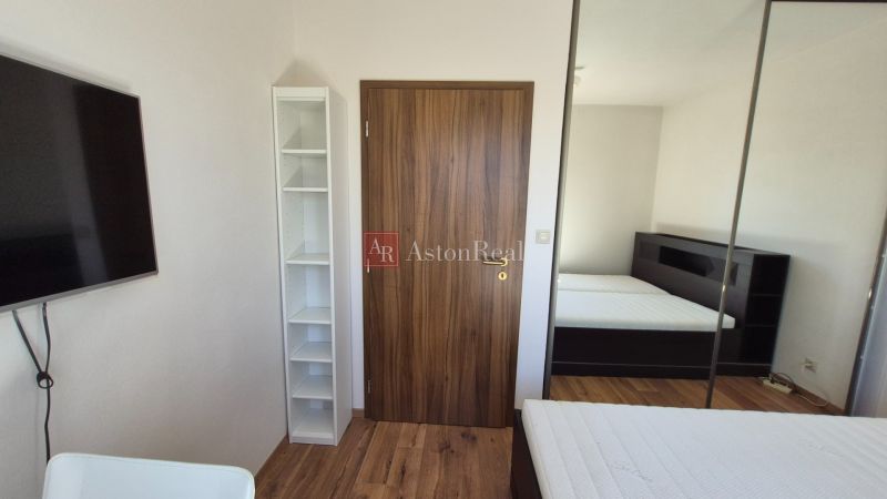 Investičný apartmán Vysoké Tatry - Stará Lesná s balkónom a park.miest - Rekreačný apartmán s posteľou, šatníkovou skriňou a podlahou s dreveným dekorom.