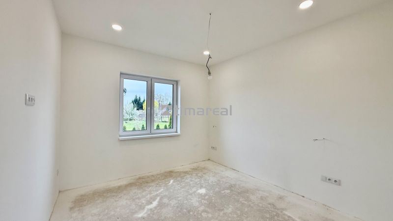 * novostavba moderného 3i domu, Vlčany, centrum - Prázdna izba v rodinnom dome s bielymi stenami a oknom s výhľadom von.