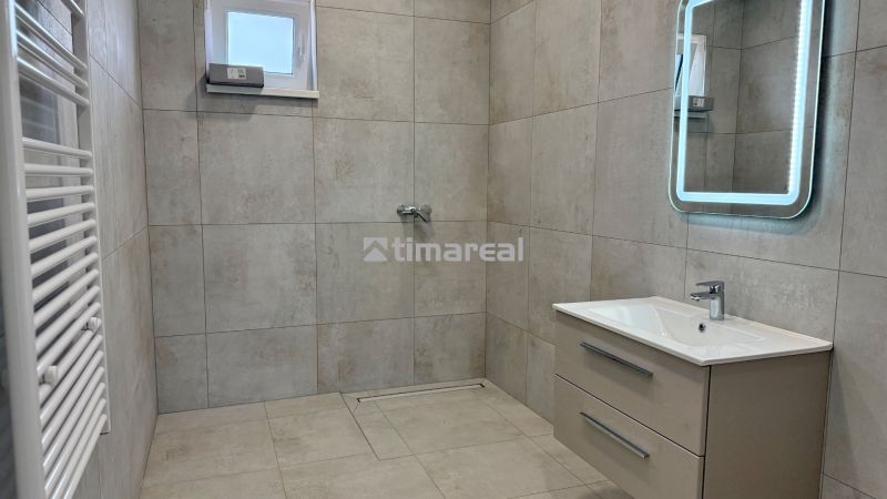 * novostavba moderného 3i domu, Vlčany, centrum - Kúpeľňa v rodinnom dome s obkladom, zrkadlom a sprchovým kútom, bezbariérový prístup.