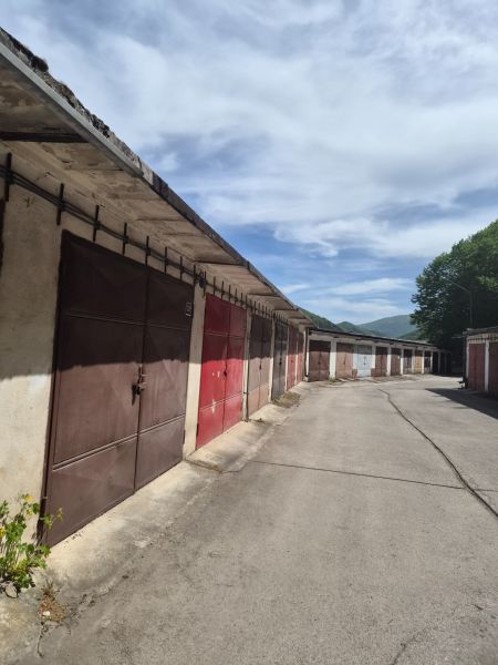Garáž Trenčianske Teplice  - Garáže na ulici Štvrť SNP v Trenčianskych Tepliciach pod modrou oblohou.