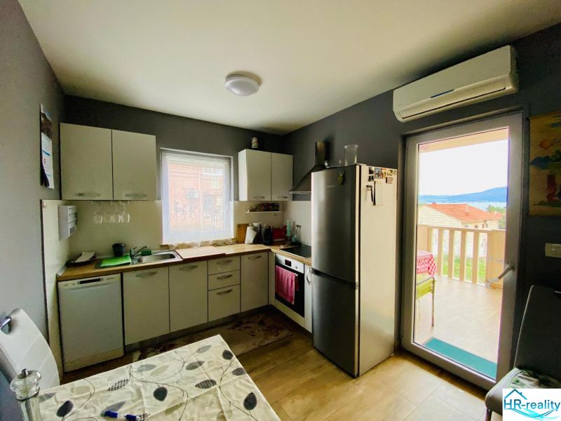 Brač(HR)–Apartmán s výhľadom na more - Kuchyňa rekreačného apartmánu s podlahou s dreveným dekorom a svetlým nábytkom.