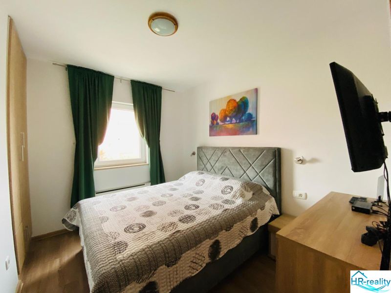Brač(HR)–Apartmán s výhľadom na more - Spálňa v Rekreačnom apartmáne s pohodlnou posteľou, dekoračným obrazom a podlahou s dreveným dekorom.