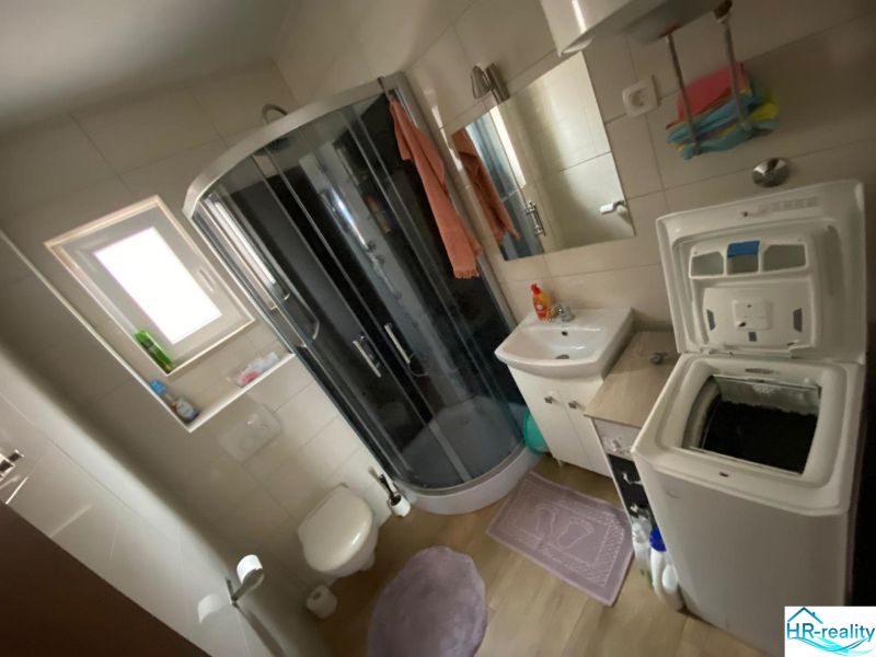 Brač(HR)–Apartmán s výhľadom na more - Kúpeľňa v rekreačnom apartmáne s práčkou, sprchovacím kútom a umývadlom.