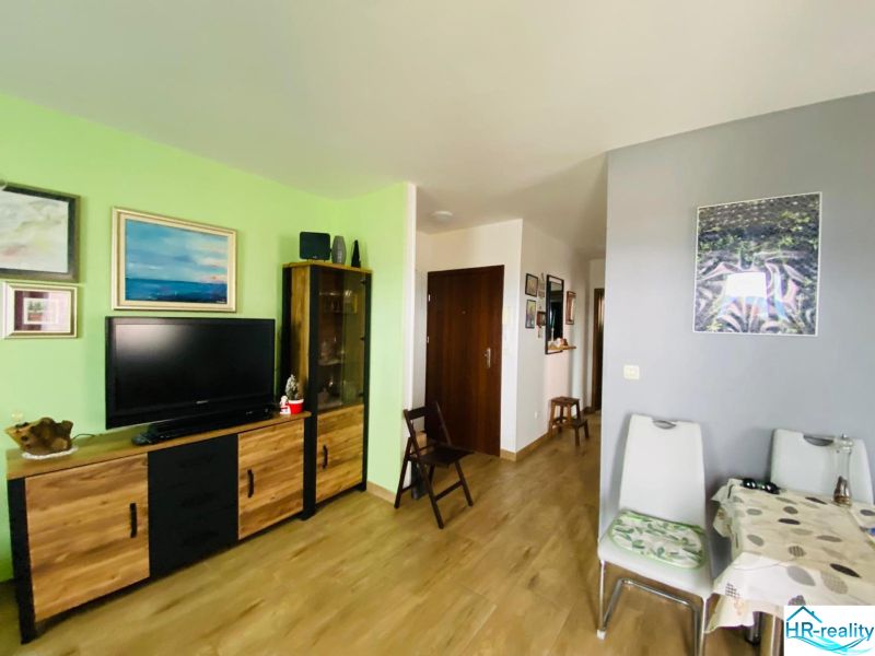 Brač(HR)–Apartmán s výhľadom na more - Obývacia izba v rekreačnom apartmáne s televízorom a dekoráciami, podlaha s dreveným dekorom.